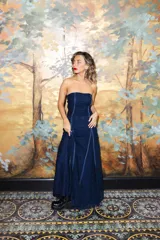 Vestido largo strapless de encaje negro con transparencias y espalda descubierta con tiras cruzadas, de corte entallado y falda de caída suelta.