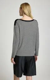 Blusa de punto a rayas horizontales en blanco y negro, con escote barco caídas de hombro y mangas largas.