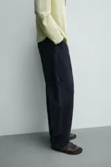 Pantalón cargo straight fit de algodón color negro con efecto lavado, bolsillos laterales en las piernas y cierre frontal con cremallera y botón.