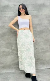 Pollera larga color blanco con estampado de flores verdes.