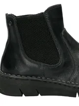 Botín tipo Chelsea de cuero negro con paneles elásticos laterales y suela de goma flexible con costura vista.