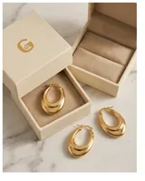 Aros tipo argolla de acero con baño de oro, diseño de doble aro superpuesto con acabado pulido.