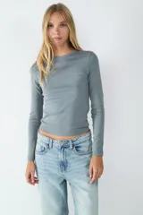 Camiseta de manga larga entallada, confeccionada en tejido elástico con cuello redondo.