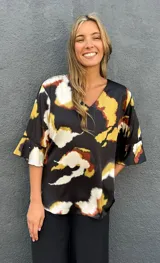 Blusa de satén con escote en V y mangas tres cuartos acampanadas, con estampado abstracto en tonos negro, caramelo, verde lima y blanco.