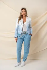 Chaqueta corta de cuero ecológico con efecto degradado de blanco a celeste. Tiene cierre frontal asimétrico, cuello con solapas y detalle de cierres decorativos.