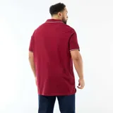 Remera de piqué color bordó, con cuello polo sin botones y detalles de líneas blancas en el borde del cuello y las mangas.