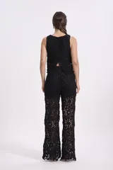 Top corto negro de crochet con diseño floral.