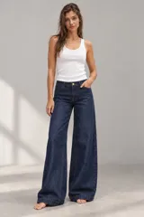 Pantalón jean azul oscuro de corte wide leg, tiro medio y confeccionado en denim 100% algodón con costuras pespuntadas en contratono.