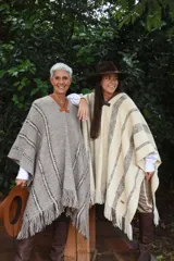 Poncho de lana tejido en telar con diseño a rayas y flecos en el ruedo, con detalle de cuero en el cuello.