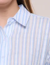 Camisa de algodón calado, con diseño a rayas en tonos celestes y blancos, cuello con solapa, cierre frontal con botones y mangas largas con puños abotonados.