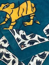 Pañuelo cuadrado de 100x100 cm, color azul marino con estampado de tigre y borde con diseño floral en color dorado.