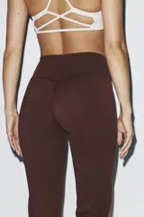 Leggings deportivos acampanados de color marrón, tiro alto y diseño ajustado con perneras amplias hacia el dobladillo.