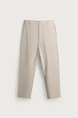 Pantalón regular fit color beige, confeccionado en tejido elástico con cintura elástica, bolsillos frontales y bolsillos traseros de vivo, con cierre frontal de cremallera y botón.