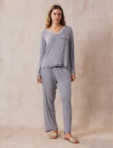 Conjunto de pijama marca René Rofé, compuesto por pantalón y remera a rayas grises y blancas. La remera es de escote en V, con bolsillo en el pecho y mangas largas. El pantalón tiene cintura elastizada y bolsillos laterales.