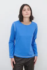 Remera de manga larga color azul, con cuello redondo y costuras decorativas a la vista en color contrastante en los puños y el ruedo.
