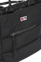 Bolso tipo tote bag color negro, con diseño acolchado y asas de mano. Incluye una correa ajustable y desmontable para llevar al hombro o cruzado. Cuenta con un bolsillo frontal con cierre y un compartimento principal también con cierre.