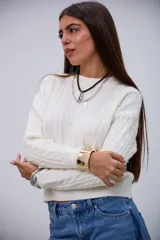 Sweater de punto color crudo con cuello redondo, diseño de ochos y mangas largas.