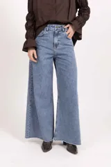 Jean wide leg de tiro alto confeccionado en denim de algodón, con pierna amplia y ruedo deshilachado.