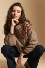 Sweater de tejido jacquard con diseño geométrico en color marrón sobre base beige, de cuello redondo y manga larga con puños ajustados.
