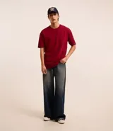 Remera de corte relaxed, confeccionada en algodón de tejido grueso con cuello redondo y mangas cortas.