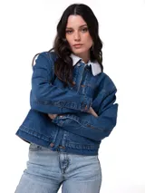 Chaqueta de jean Caterpillar, modelo W Sherpa Lined Relax, de color azul con forro de sherpa blanca en el cuello. Cuenta con cierre frontal de botones metálicos, bolsillos frontales de parche y costuras en contraste.