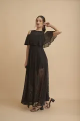 Vestido largo negro con hombros descubiertos, volados en el pecho, mangas cortas y paneles de encaje transparente en la falda.