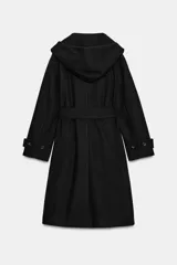 Abrigo de paño negro con capucha, cierre frontal cruzado con botones y cinturón de lazada en el mismo tejido. Presenta manga larga con trabillas en los puños y bolsillos laterales.