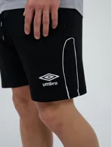 Bermuda deportiva Umbro modelo Veliz para hombre, color negro con detalles en blanco, cordón ajustable en la cintura y logo bordado en la pierna izquierda.