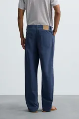 Pantalón de algodón azul marino, de corte recto (straight fit) con cinco bolsillos y cierre frontal de cremallera y botón.