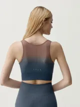 Top deportivo sin mangas de diseño degradado que transiciona de beige en los hombros y pecho a verde oscuro en la parte inferior, con escote redondo y sostén integrado.