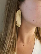 Aros colgantes grandes de bronce color dorado con forma irregular.