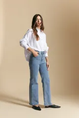 Jean de corte recto y tiro medio, confeccionado en denim con elastano. Presenta apliques de tachas metálicas en la zona de los bolsillos delanteros, aportando un detalle distintivo y moderno.