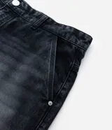 Bermuda de jean color gris oscuro con efecto de lavado, corte baggy relaxed. Presenta apliques de estrellas deshilachadas en los laterales y ruedo deshilachado. Tiene cintura con trabillas y cierre tradicional.