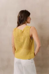 Chaleco tejido calado de color amarillo, con escote redondo, tirantes anchos y calce relajado. Cuenta con terminaciones en rib en el ruedo.