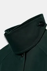 Trench midi ZW Collection verde oscuro con cuello solapa, manga larga, bolsillos laterales en costura y cierre frontal con botones. Cuenta con forro interior a contraste y detalle de solapa corta en el pecho.