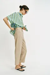 Pantalón de tiro medio con diseño barrel, pernera holgada que se estrecha hacia el tobillo y detalle de raya planchada en el frente y la espalda. Cuenta con cinco bolsillos y cierre frontal con cremallera y botón.