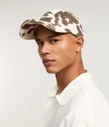 Gorra de sarga con estampado animal print de vaca, modelo dad hat con visera curva y ajuste trasero. Confeccionada en algodón sostenible.