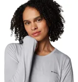 Remera de manga larga Columbia, color gris, con cuello redondo y orificios para los pulgares en los puños. Presenta tecnología de protección solar y absorción de humedad, con logo de la marca estampado en el pecho.