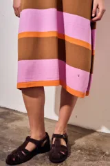 Sandalia cangrejera de gamuza color marrón oscuro, con puntera cerrada y tiras entrecruzadas. Posee tira de ajuste con hebilla metálica dorada en el tobillo y suela de goma plana.