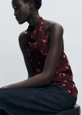 Top halter marrón con estampado de rosas rosadas, espalda descubierta y cierre de lazo en el cuello. Diseño entallado.