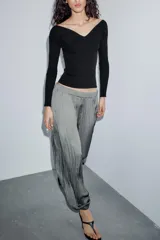 Pantalón de tiro medio con cintura elástica y bajo acabado en puño elástico. Presenta un diseño con tejido efecto arrugado y bolsillos laterales ocultos en costura.