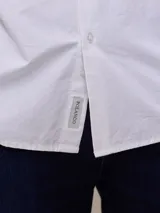 Camisa negra de algodón de manga larga, con cuello clásico y cierre frontal con botones.