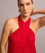 Túnica larga roja con textura jacquard de formas geométricas cuadradas, cuello halter con lazo para anudar y espalda descubierta.