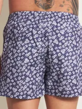 Bóxer de algodón blanco con estampado de flores pequeñas color celeste, con cintura elástica y logo de la marca en el centro.