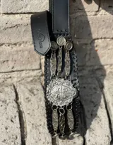 Cinturón de cuero negro tipo rastra, con apliques de metal plateado y diseño central con el escudo de Uruguay.