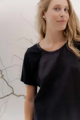 Remera blanca de manga corta con escote redondo y detalle de pespunte calado en la zona de las sisas.