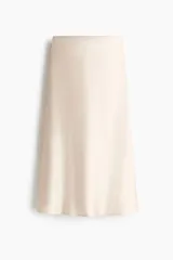 Pollera midi de tiro alto, color beige, confeccionada en tela satinada de caída suave con acabado brillante y leve vuelo en el bajo.