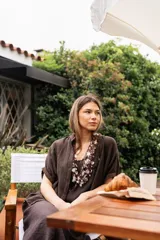 Collar de hilos tejidos color marrón con escamas de pescado y detalles de nácar blanco.