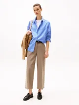 Pantalón de vestir color beige, de corte tobillero y pierna ancha. Confeccionado en tejido antiarrugas de mezcla de poliéster, viscosa y elastano. Presenta cierre de cremallera con enganche oculto, raya marcada en la parte delantera y trasera, y dos bolsillos traseros de ojal.