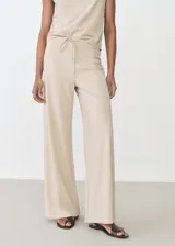 Pantalon wide leg de tiro alto, confeccionado en tejido fluido con cintura elástica y lazo ajustable.